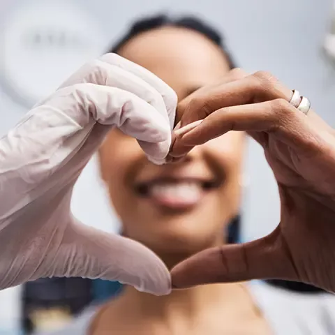 Dental hygienist making heart shape with hands